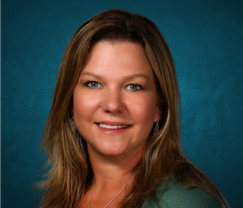 Kristen Carroll in front of a blue background