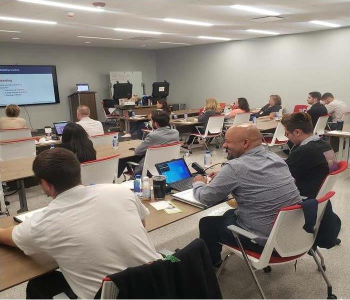 Men and women sitting at tables in a training room